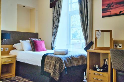 a bedroom with a bed and a window at The Cornhill Inn in Falkirk
