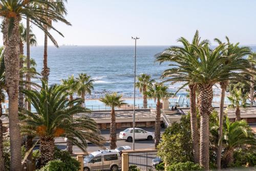 a view of a beach with palm trees and cars at Mojo Hotel & Market in Cape Town