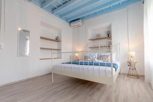 a white bedroom with a white bed and a blue ceiling at Xenofon Traditional Rooms in Rhodes Town