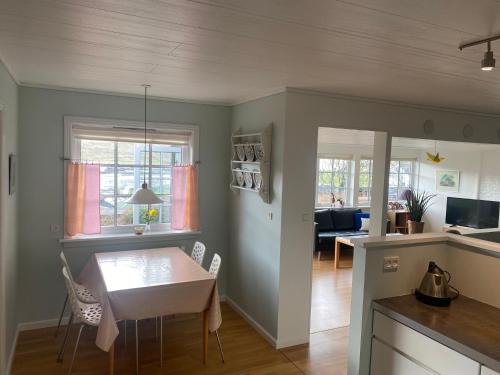 a kitchen and living room with a table and chairs at Cosy house with stunning view in Sørvágur