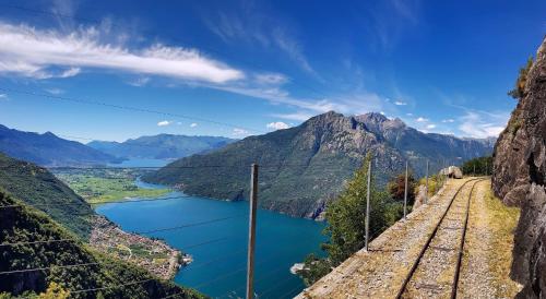 a train track next to a lake and mountains at Casa Viola - Near the beach in Domaso
