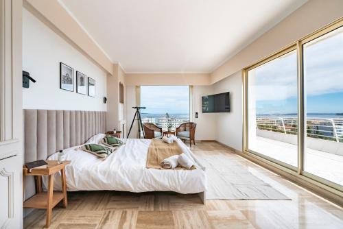 une chambre avec un lit et une grande fenêtre dans l'établissement Appartement vue mer panoramique, à Cannes