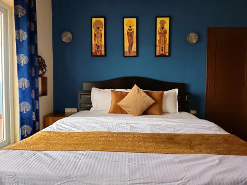 a bedroom with a bed with four pictures on the wall at KALON ELPIS Tea Estate Villa in Lovedale