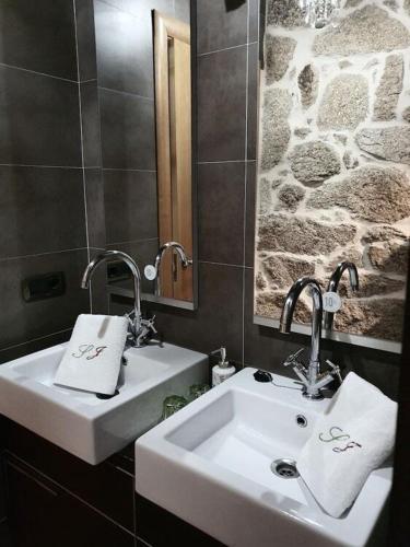 a bathroom with two sinks and a mirror at Hotel Rústico San Jaime in Ourense