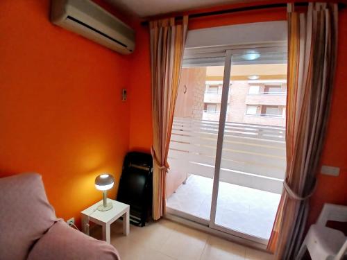 a living room with a large window and a couch at Acapulco II, 1a LINEA, Playa Amplaries in Oropesa del Mar