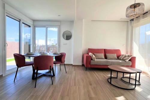 a living room with a red couch and a table at Golf sun and a private pool for a dream holiday! in Orihuela