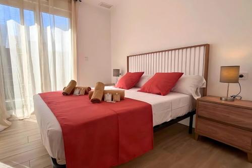 a bedroom with a large bed with red pillows at Golf sun and a private pool for a dream holiday! in Orihuela