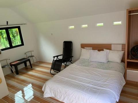 a bedroom with a large white bed and a window at Zico Homestay in Andalas