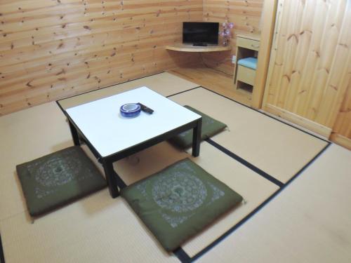 a room with a table and four mats in it at Sendaiya in Hida