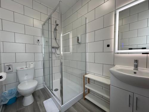a bathroom with a shower and a toilet and a sink at The Royal Clarence Hotel (on the Seafront) in Burnham on Sea