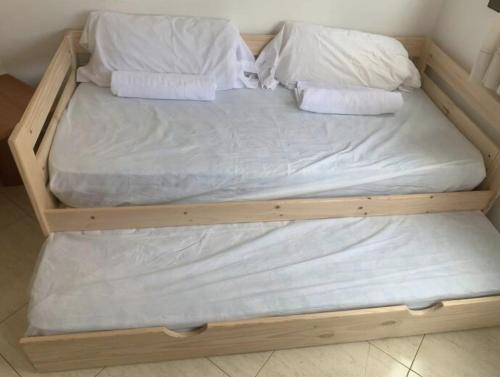 a wooden bed with white sheets and pillows on it at olinva mar in Lloret de Mar