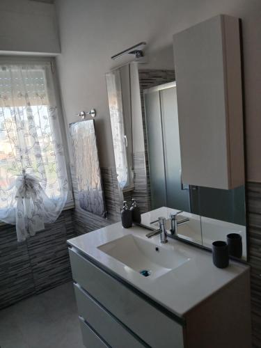 a bathroom with a sink and a mirror at La Torretta Sul Porto - Parcheggio gratuito in Livorno