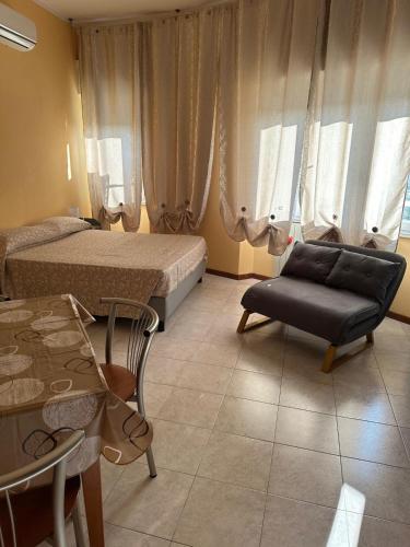 a bedroom with two beds and a couch and a table at La Torretta Sul Porto - Parcheggio gratuito in Livorno