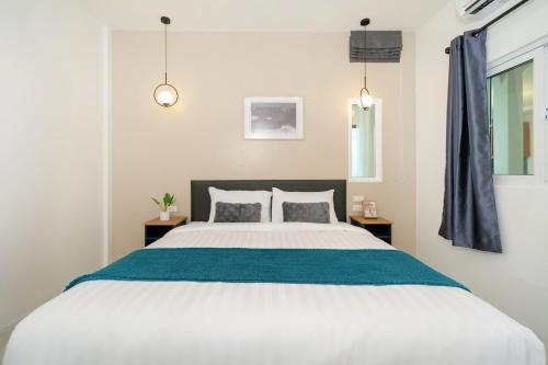 a bedroom with a large white bed with blue sheets at 6BR Patong pool villa in Patong Beach