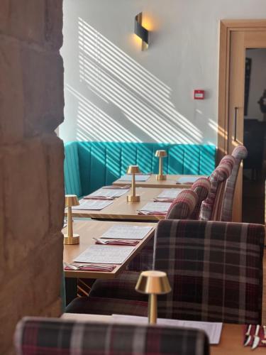 a row of long tables in a room with plaid chairs at The Cornhill Inn in Falkirk