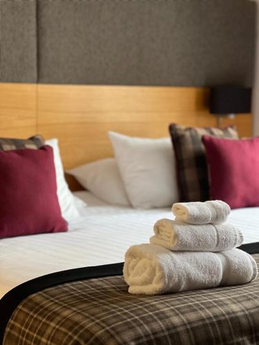 a pile of towels sitting on top of a bed at The Cornhill Inn in Falkirk