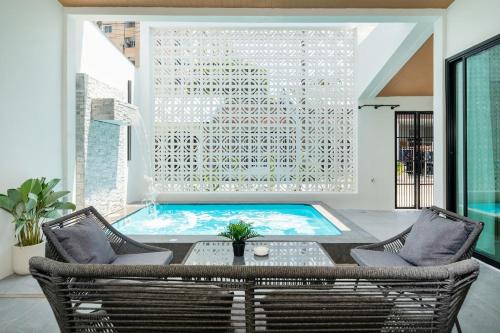 a swimming pool in a room with two chairs and a table at 6BR Patong pool villa By MP property in Patong Beach