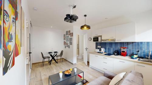 une cuisine et un salon avec un canapé et une table dans l'établissement expat renting - L'Artiste - Netflix - Proche gare, à Toulouse