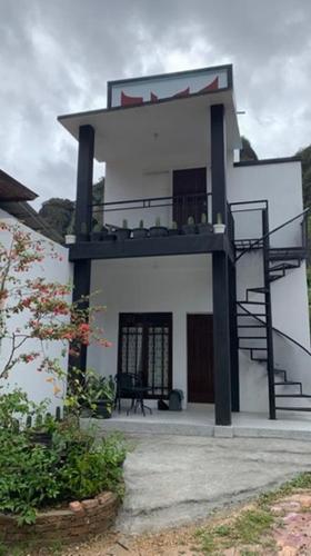 a building with a balcony and stairs on it at Zico Homestay in Andalas