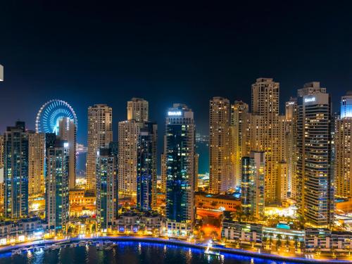 a night view of a large city with lights at Vida Yacht Club # Up-scale 2BHK # Marina,Sea & Ain View in Dubai