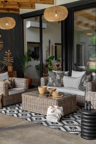 a living room with wicker furniture on a rug at Sashwa River of Stars Plant-Based Wellness Safari Lodge in Hoedspruit