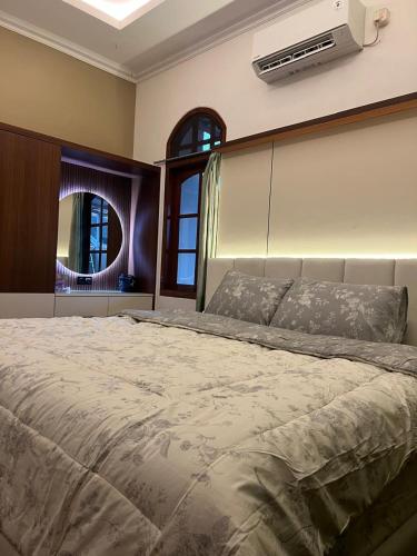 a bedroom with a large bed with a air conditioner at Guest House Omah Ningrat Surabaya in Surabaya