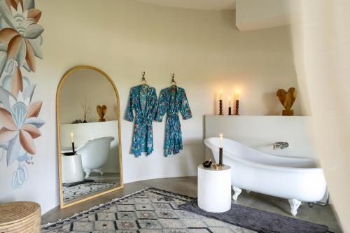 a bathroom with a tub and a mirror at Sashwa River of Stars Plant-Based Wellness Safari Lodge in Hoedspruit