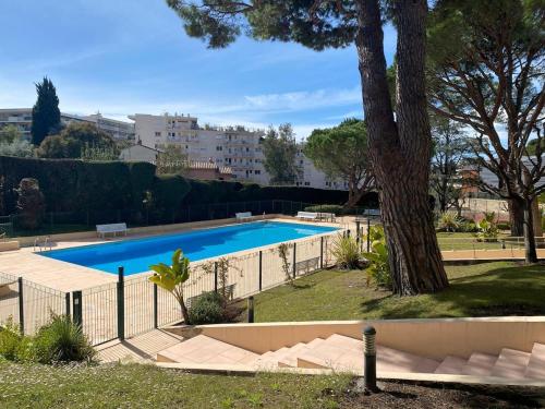 - une piscine dans une cour avec un arbre dans l'établissement Centre-Ville Le Cannet - Piscine, Tennis, Parking - À 10 min de la Croisette ! - Azur Eden, au Cannet