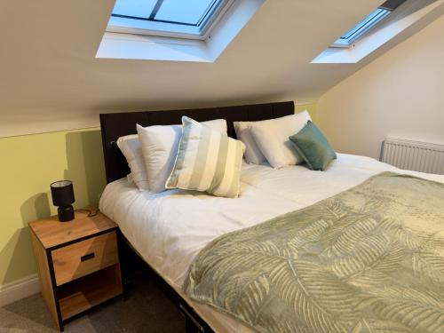 une chambre avec un lit avec des oreillers et une fenêtre dans l'établissement Fletcher - A Converted Church Luxe Apartment, à Gillingham