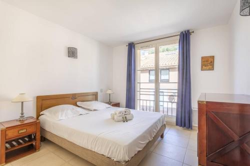 a bedroom with a bed with two teddy bears on it at Superbe T2 refait à neuf proche du centre du village et de la Mer in Porquerolles