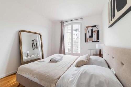 une chambre avec un grand miroir et un lit dans l'établissement Cosy 2 Pieces au Coeur du 19e - 4P, à Paris