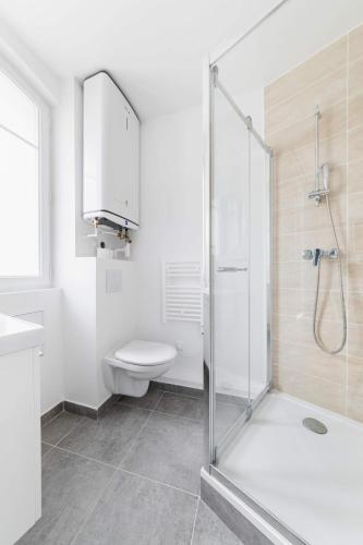 une salle de bain avec douche et toilettes dans l'établissement Cosy 2 Pieces au Coeur du 19e - 4P, à Paris