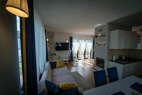 a living room with a couch and a kitchen at Domek IMIONEK Wrota Mazur in Maldanin