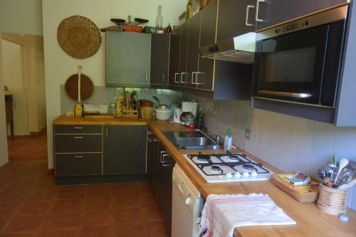 a kitchen with a sink and a stove top oven at Agréable villa fleurie sur l'ile de Porquerolles in Porquerolles