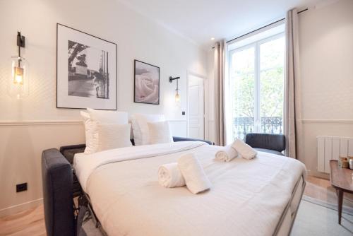 une chambre avec deux lits avec des serviettes dessus dans l'établissement Appartement luxe 2 chambres Grands Boulevards 4-6P, à Paris