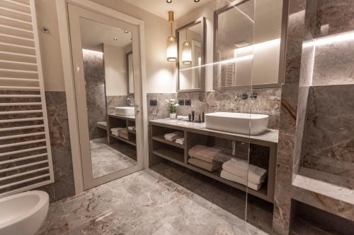a bathroom with two sinks and two mirrors at Park Hotel Imperial in Limone sul Garda