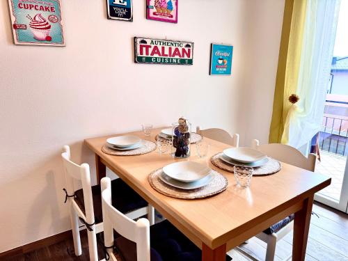 a dining room table with plates and glasses on it at Casa Viola - Near the beach in Domaso