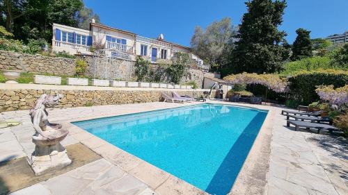 - une piscine avec une statue à côté d'un bâtiment dans l'établissement Villa 4 BR with pool, 5 minutes Cannes, au Cannet