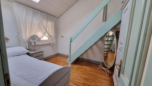 a small bedroom with a bed and a staircase at Anto in Campitello di Fassa