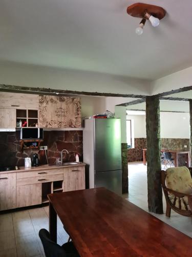 a kitchen with a table and a green refrigerator at Havva in Călimăneşti