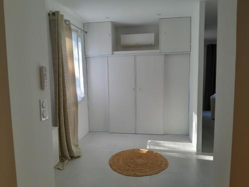a bathroom with white cabinets and a rug on the floor at MAISON au calme en pleine nature 2 PERSONNES in Fayence