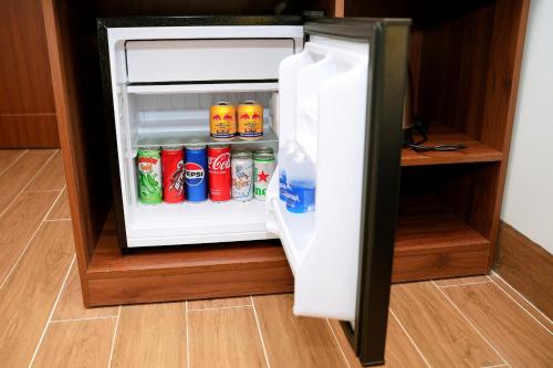 an open refrigerator with sodas and drinks in it at Suka Hotel in Tây Ninh