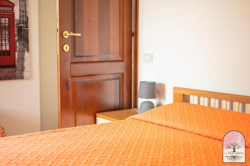 a bedroom with a bed and a wooden door at Il Pepe Rosa in Posada