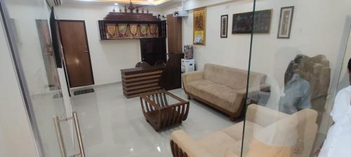 a living room with a couch and a chair at SSK Rooms in Gūduvāncheri