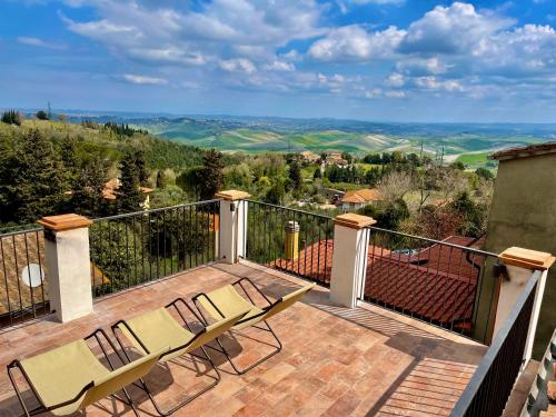 a balcony with chairs and a view of the hills at Le Vecchie Cantine in Chianni