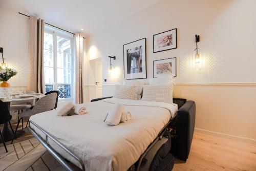 un grand lit dans une chambre avec une table dans l'établissement Luxury Central 3 Bedrooms Flat - Grands Boulevards, à Paris