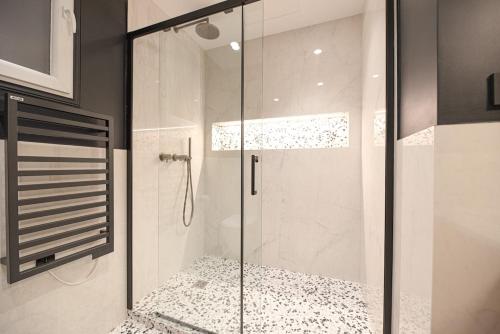 une douche avec une porte vitrée dans une salle de bain dans l'établissement Luxury Central 3 Bedrooms Flat - Grands Boulevards, à Paris