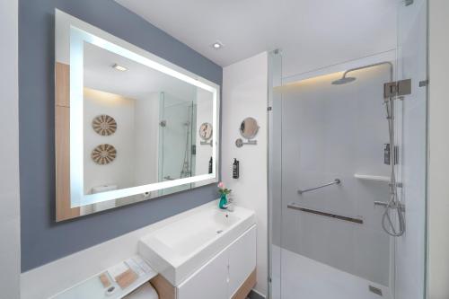 a bathroom with a white sink and a mirror at Andaman Beach Hotel Phuket - Handwritten Collection in Patong Beach
