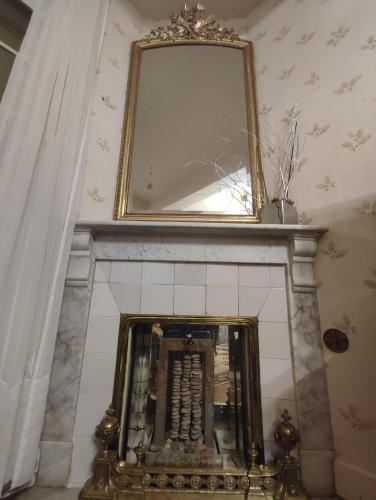 a mirror on top of a fireplace in a room at Grande Maison Simone-Climatisation-Parking-Terrain in Carcassonne