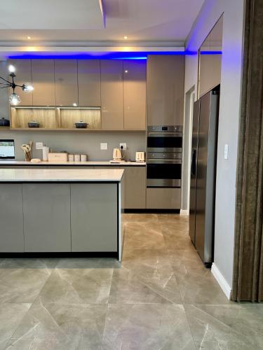 a large kitchen with stainless steel appliances and purple lighting at The Views at 492 Euphoria Golf Estate in Naboomspruit